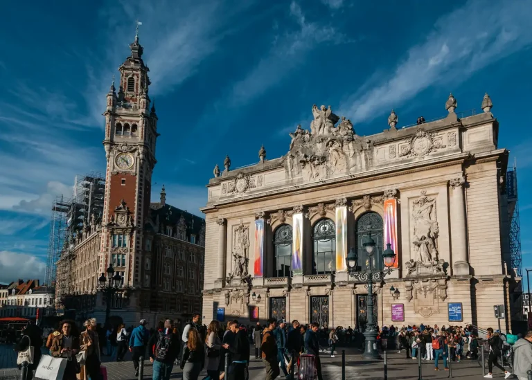 L’Opéra de Lille et le beffroi de la Chambre de commerce, place du Théâtre, avec des passants devant les façades