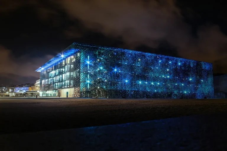 Le Mucem illuminé de bleu, la nuit, sur l’esplanade du J4 à Marseille