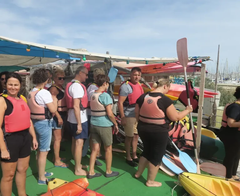 Participants du séminaire Swiss Life en gilet de sauvetage, souriants, à la base de kayak de l’île du Frioul, avant leur sortie en mer
