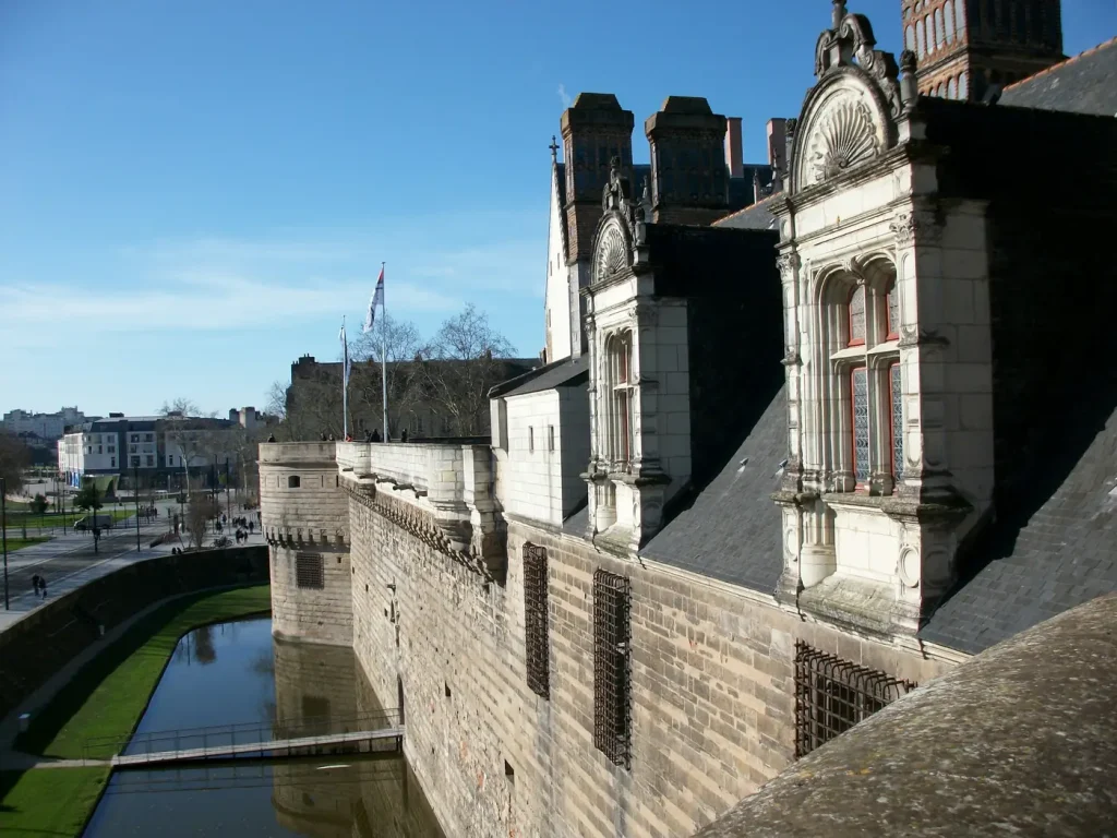Les remparts, les douves et les lucarnes sculptées du Château des ducs de Bretagne, à Nantes, sous un ciel bleu