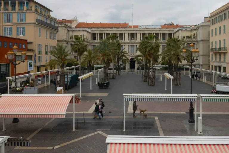 Le palais de la Préfecture et ses palmiers sur la place Pierre-Gautier, près des auvents rayés du marché du cours Saleya, dans le Vieux Nice