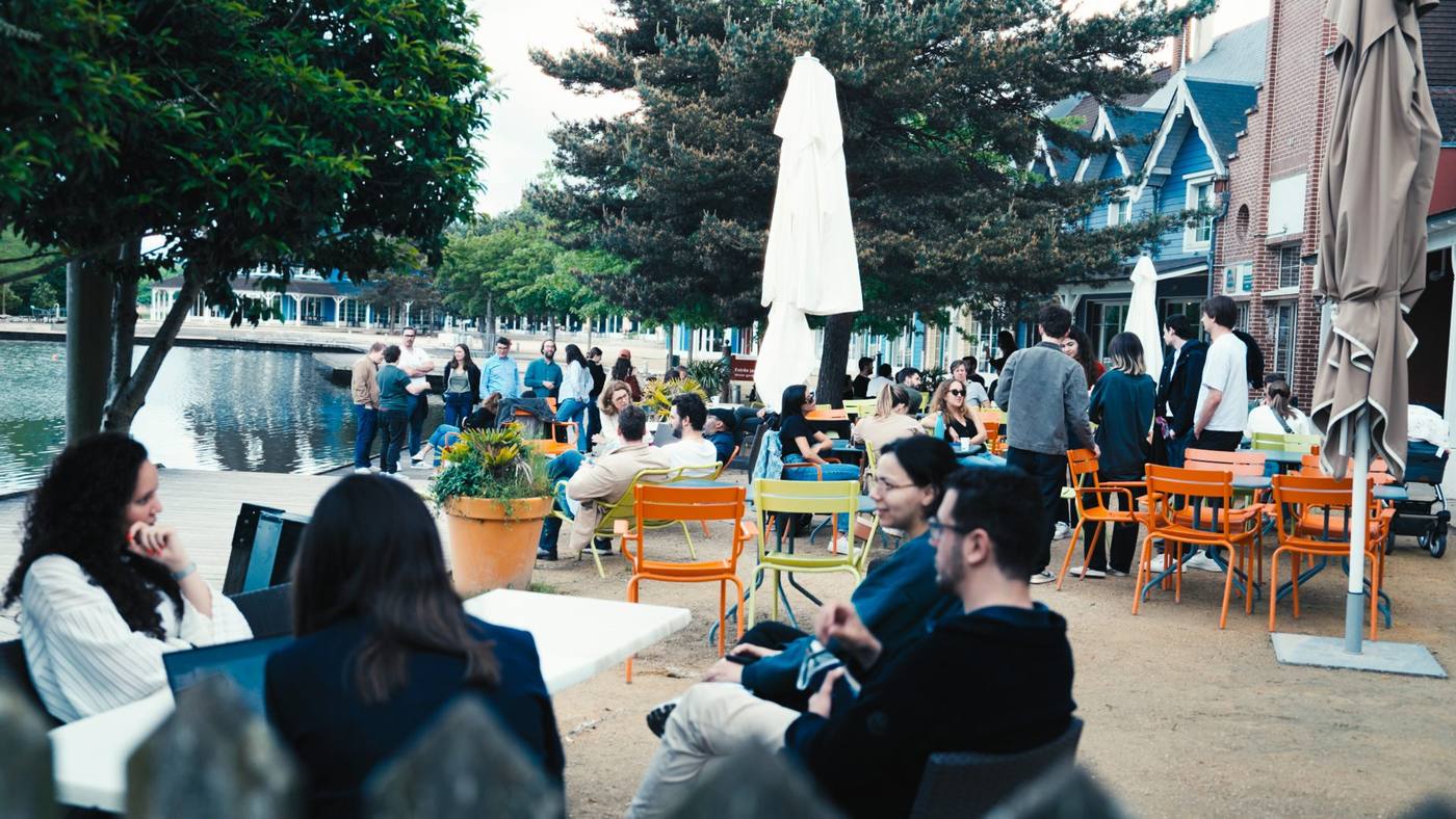 Participants du séminaire KPMG installés en terrasse au bord du lac, entre parasols et chaises colorées, au Center Parcs du Lac d'Ailette où Weevup a organisé l'événement