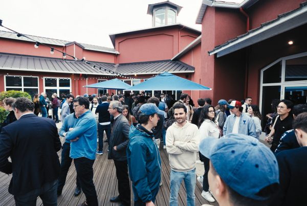 Participants du séminaire KPMG réunis sur une terrasse en bois devant les bâtiments rouges du Center Parcs du Lac d'Aillette, pendant le séminaire organisé par Weevup pour 900 personnes