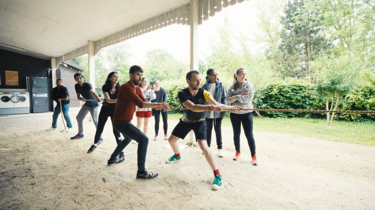 Participants du séminaire KPMG tirant ensemble sur une corde en plein air, pendant les activités de team building organisées par Weevup
