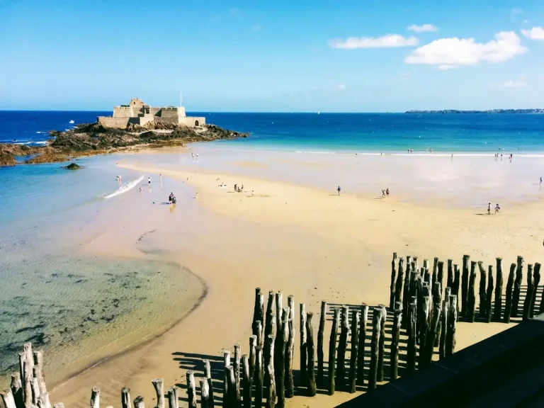 Plage de Saint-Malo à marée basse, ses brise-lames en bois et le Fort national sur son îlot