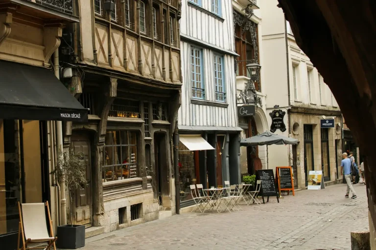 Rue pavée bordée de maisons à colombages et de terrasses, dans le centre historique de Rouen