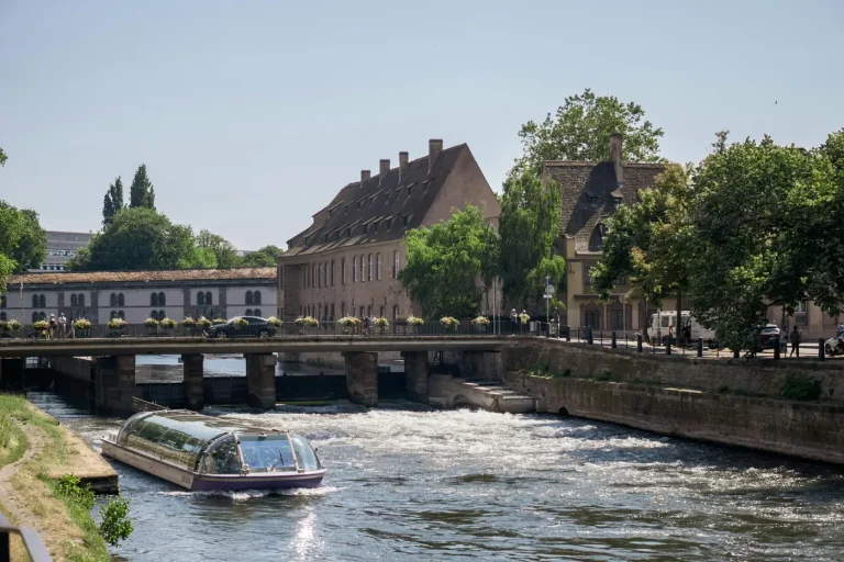 Un bateau de promenade sur l’Ill, au pied des bâtiments en grès rose du centre de Strasbourg