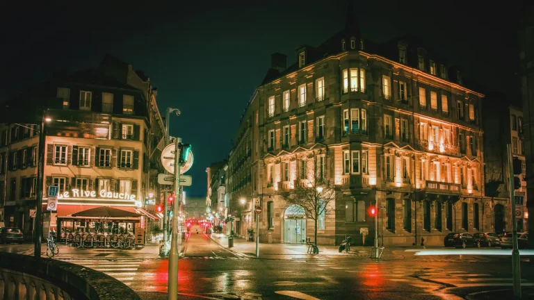 Brasseries et façades illuminées à un carrefour du centre de Strasbourg, la nuit
