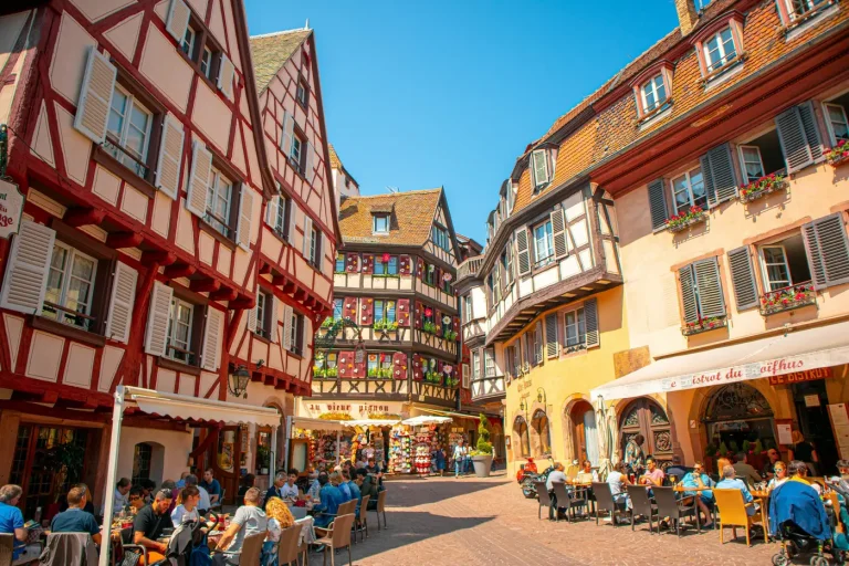 Terrasses animées au pied de maisons à colombages colorées, dans le centre historique de Colmar